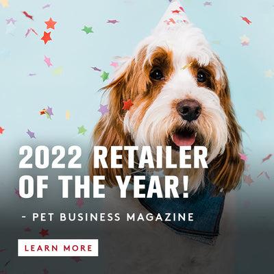A long haired dog with white and brow hair with a party hat on, with confetti falling around it. We are the 2022 Retailer of the year - pet Business Magazine. Learn More